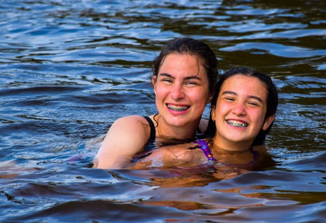 Two girls swimming in the lake.