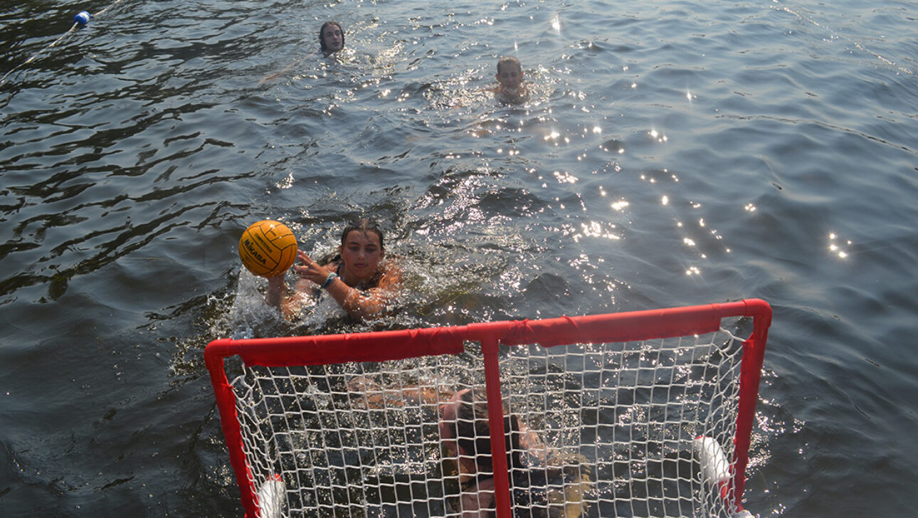 Campers playing handball in a lake.