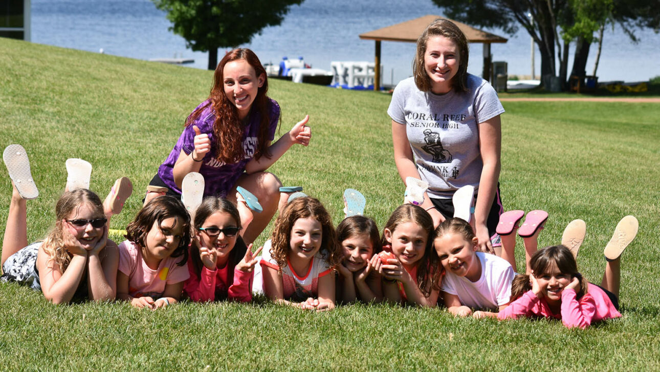 Two Camp Ramah Wisconsin staff members along with a group of young campers.