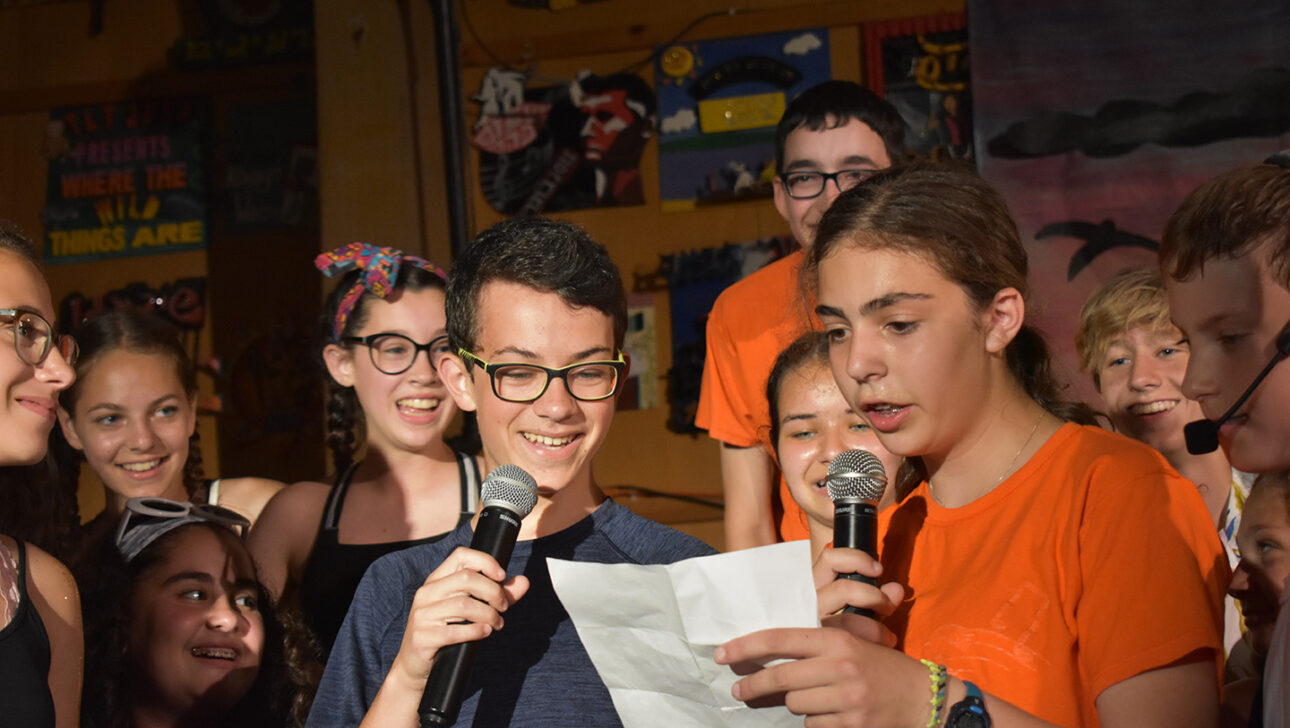 Two campers reciting something on stage.