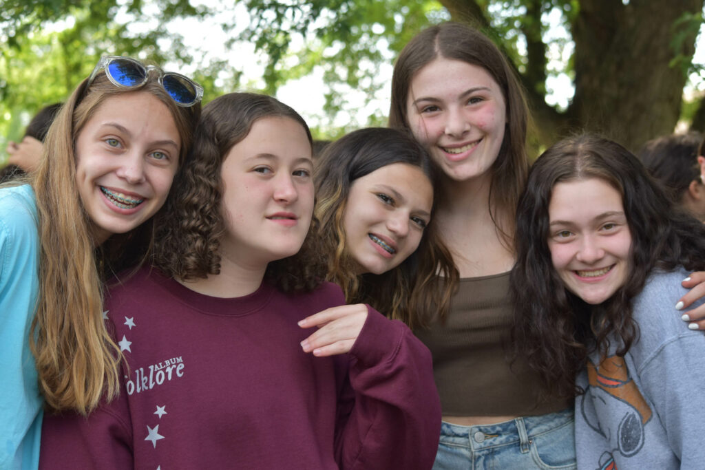 Group of camper friends smiling for a photo.
