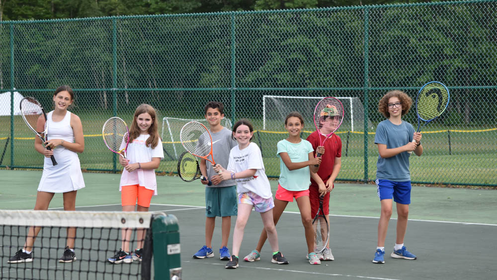 Group of campers with tennis raquets.