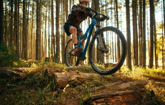 A camper biking through the woods.