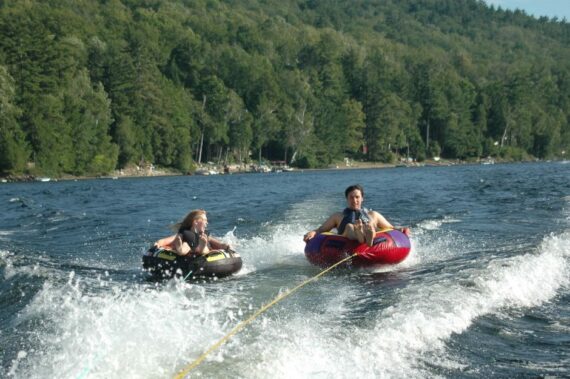 Two campers tubing on the water.