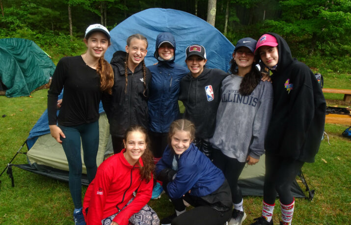 Group of teenagers in front a tent.
