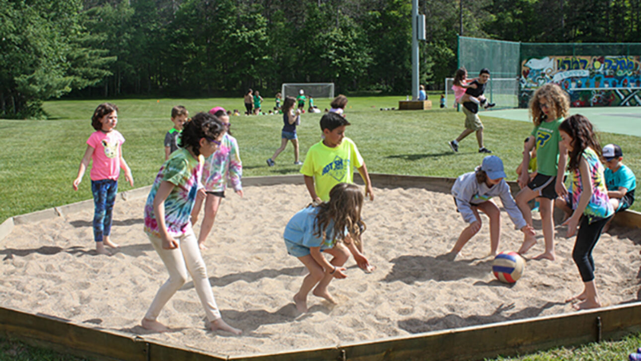 Young campers playing in a sandbox.