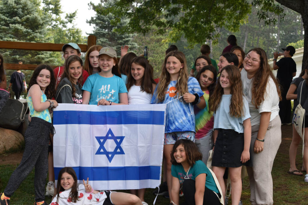 Group photo holding the Israeli flag.
