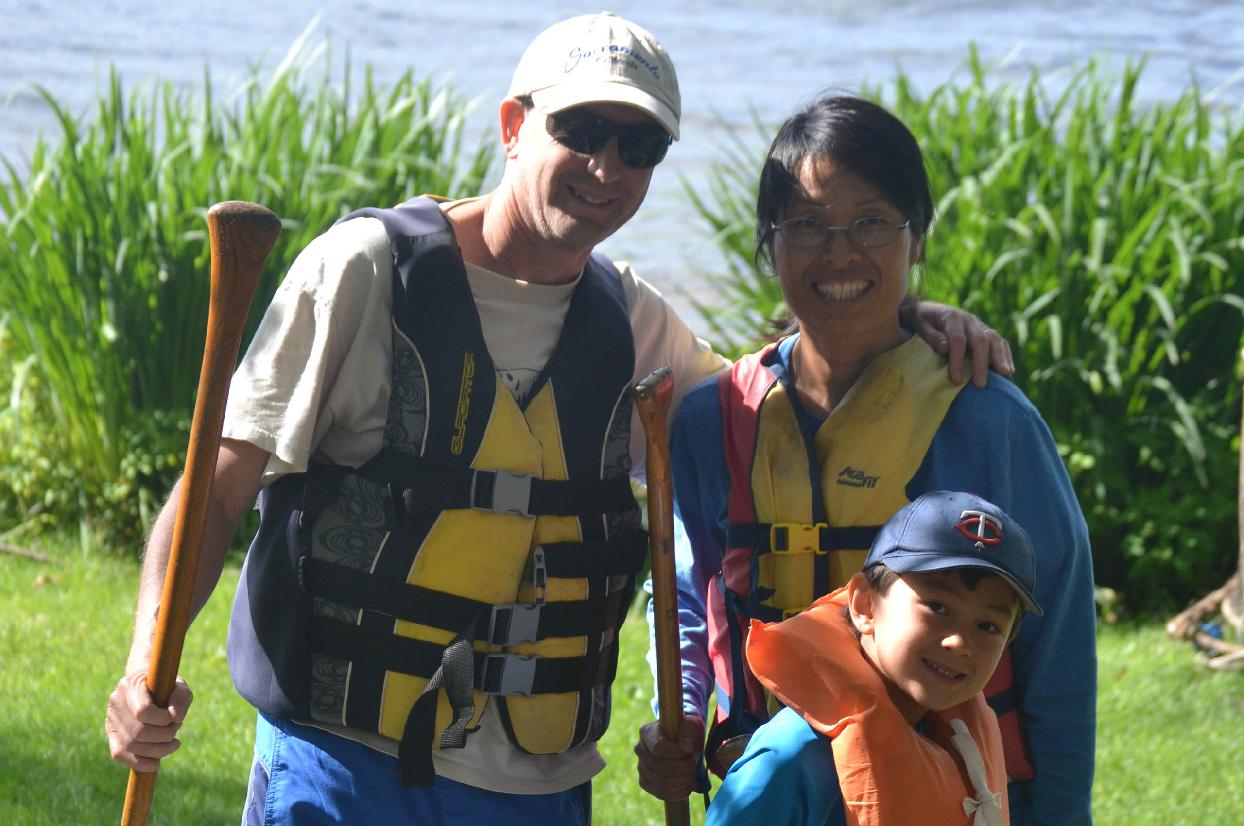 A family of three wearing life jackets.